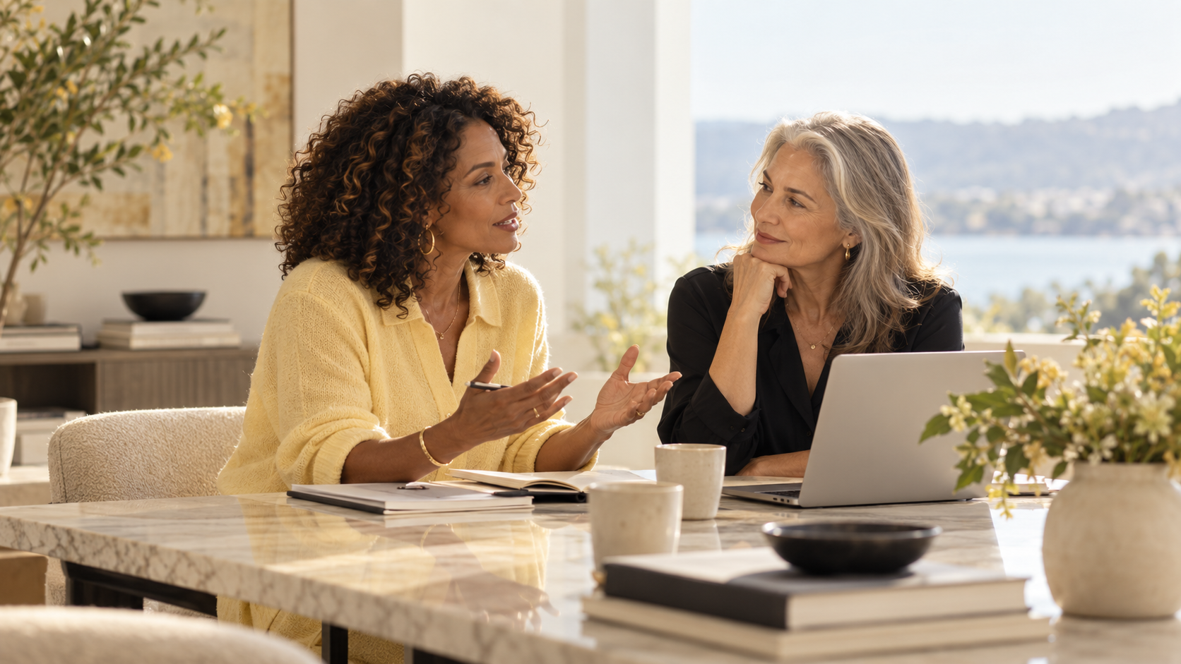 Two experienced women discussing business together at a table